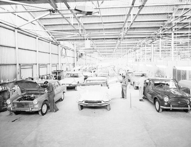 Monochrome photograph of a vehicle manufacturing plant.