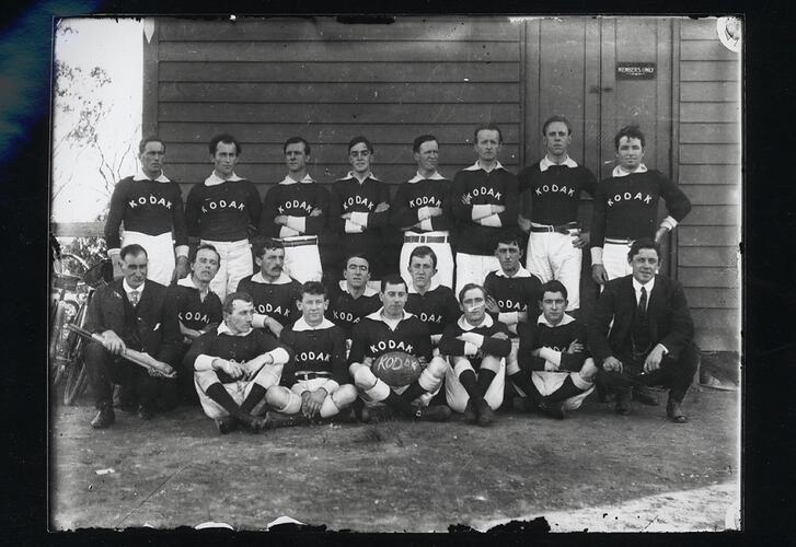 Group portrait of male football team in uniform.