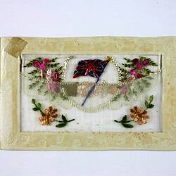 Back of postcard with embroidered flowers and flags.