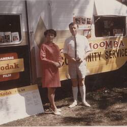 Man and woman with promotional Kodak caravan.