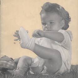 Cover page with photograph of baby removing sock.