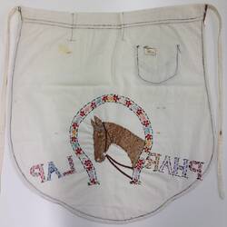 Back of white apron with brown trim and embroidered horse head.