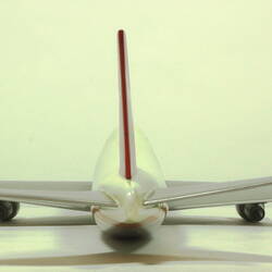 White model plane with red trim and tail. Grey wings. Back view.