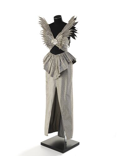 Evening dress, full length, silver-grey silk. No sleeves, winged shoulder peaks, cut-out midriff.