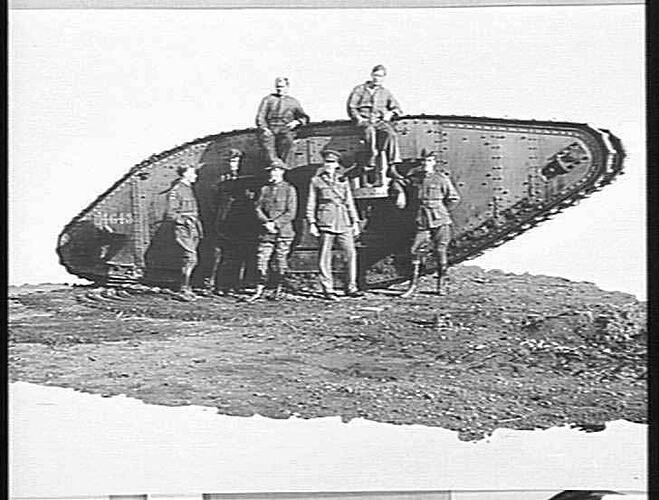 World War I soldiers standing with a Mark IV tank.