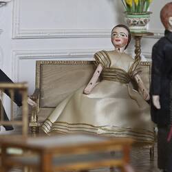 Doll's house interior room. Furnished and featuring costumed figures.