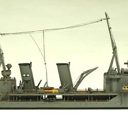 Naval ship with two masts, facing right.