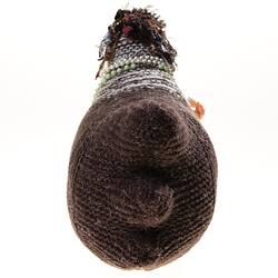 Hand-knitted brown chicken with pink rosettes and necklaces around its neck. Back view.