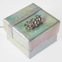 Rectangular brooch with 17 round diamantes on silver white gift box.