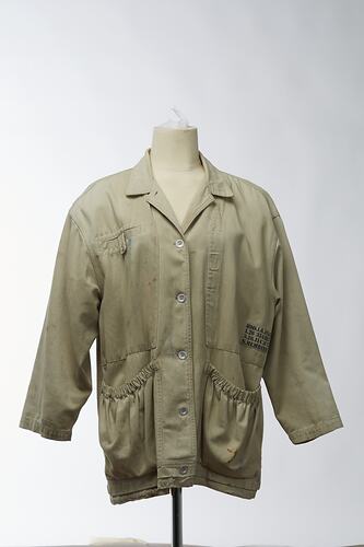 Beige canvas coat with large elasticised pockets. Front view.