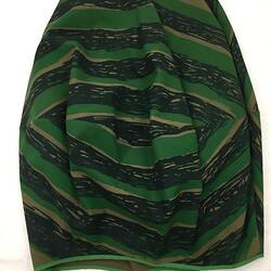 Back of khaki fabric skirt with printed large eye pattern.