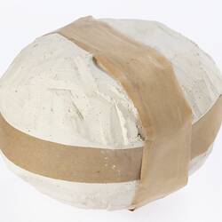 Round plaster mould with brown tape around top and side.