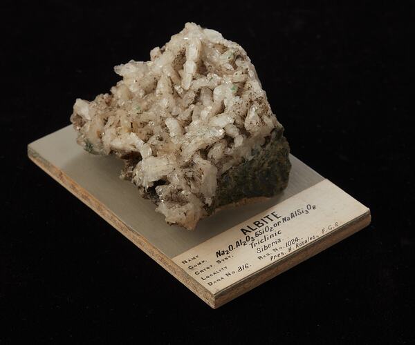 Rock made of many columnar white crystals with dark flecks.