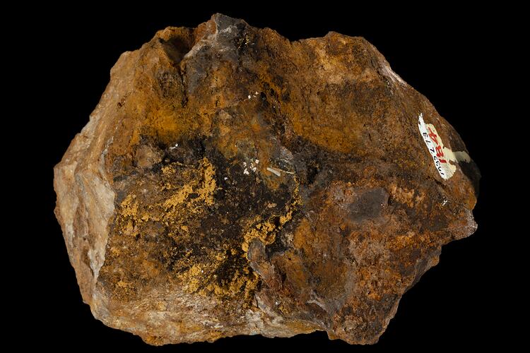 Irregular orange and brown rock with gold streaks.