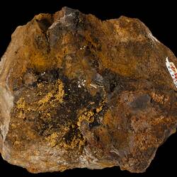 Irregular orange and brown rock with gold streaks.
