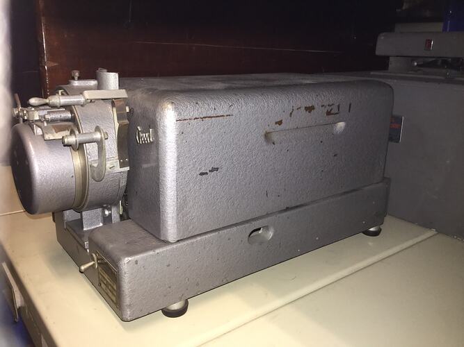 Rectangular metal box with switch at end. Rubber pads on feet.