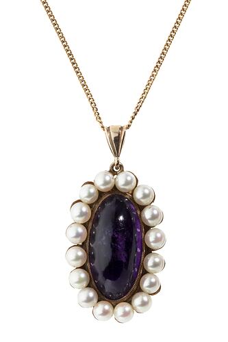Elongated oval amethyst pendant framed by 16 small pearls suspended from a fine gold chain.