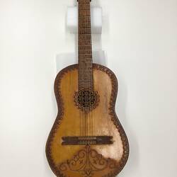 Brown wooden mandolin neck with yellowish pattern.