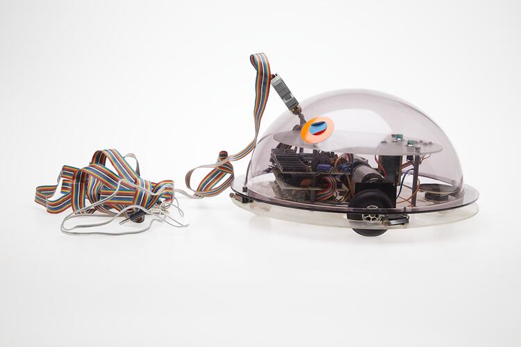 Profile of clear dome containing computer components. Cable attached.