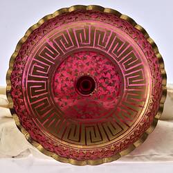 Round top of red glass plate-shaped epergne with gilded decoration.