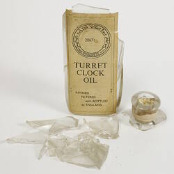 Broken glass bottle with label.