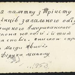 Back of white rectangular photograph with handwritten text in blue ink.