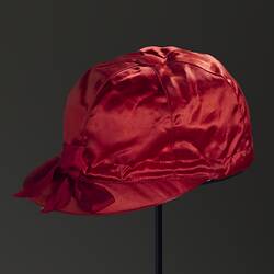 Red silk jockey cap. Black background.
