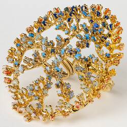 Large-scale, openwork design gold oval ring set with multicoloured microplastics.