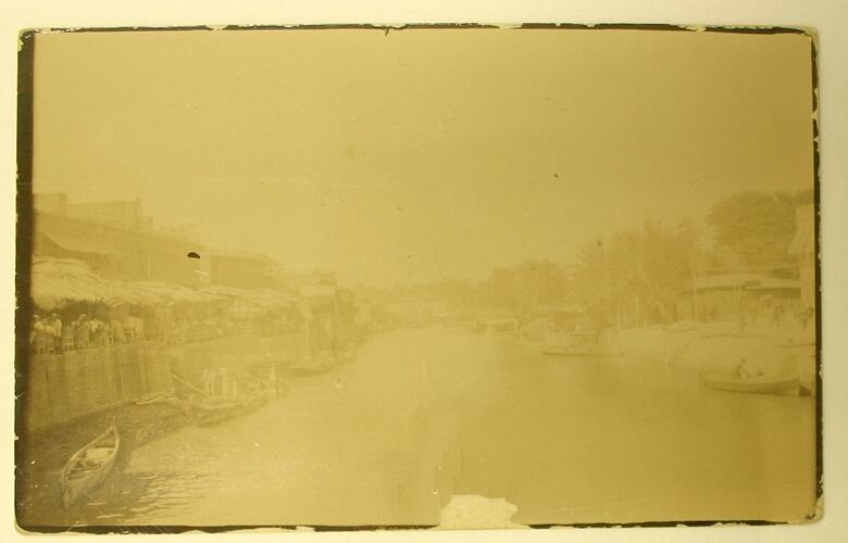 Creek lined with boats and buildings.