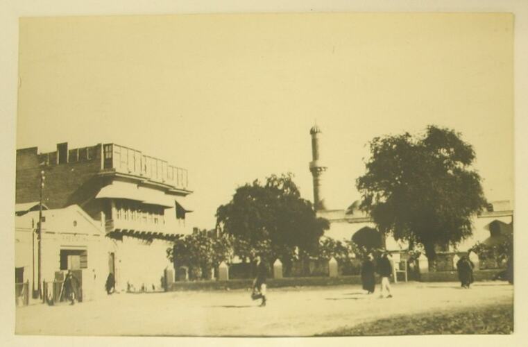 Village scene with a minaret visible in the background.