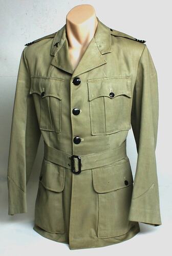 Khaki jacket, two breast pockets and two hip pockets. Cloth belt with buckle.