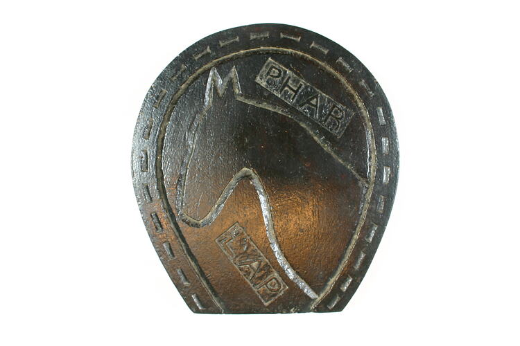 Base of object, carved horse shoe and horse.