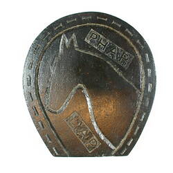Base of object, carved horse shoe and horse.