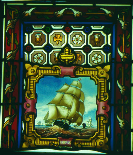 Stained glass window showing large sailing ship at sea.