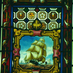 Stained glass window showing a coat of arms.