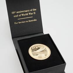 Open black box with round gold medal.