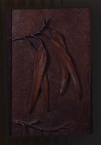 Front of wooden screen with carved eucalyp leaves.
