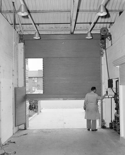 Negative - Man Operating Roller Door, Port Melbourne, Victoria, Oct 1953