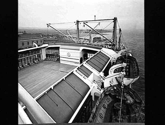 Ship deck with painted circular games. Life rafts at right.