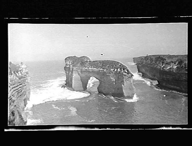 An arch-shaped rock structure in the sea.