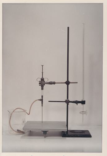 Laboratory stand with burette, hose, and beaker.