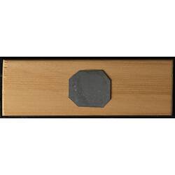 Underside of wooden microslide with octagonal metal central panel.