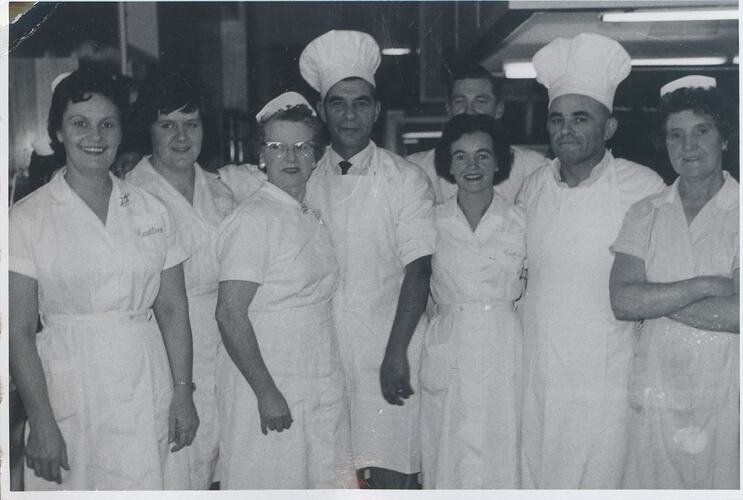Group in uniforms, two men in chef hats.