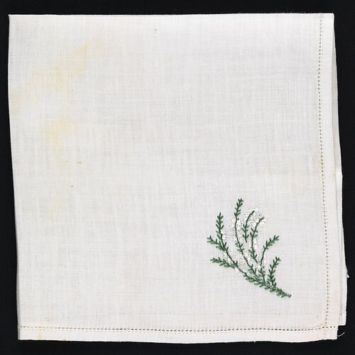 Folded handkerchief with embroidered white heather.