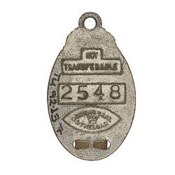 Back of badge with lettering.