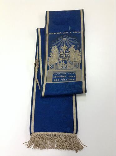 Blue sash with white fringing, text and emblem.