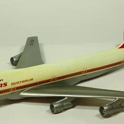 White model plane with red trim and tail. Grey wings. Left front three quarter view.