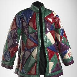 Quilted geometric plastic jacket filled with coloured feathers. Quilted sections are triangular.