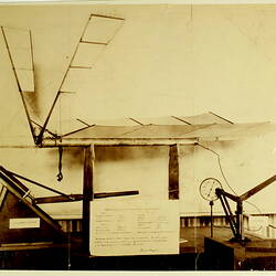 Model airplane on bench with information sheet in front.