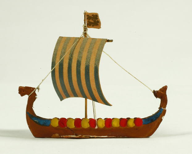 Side view of ship with dragon head and shields.